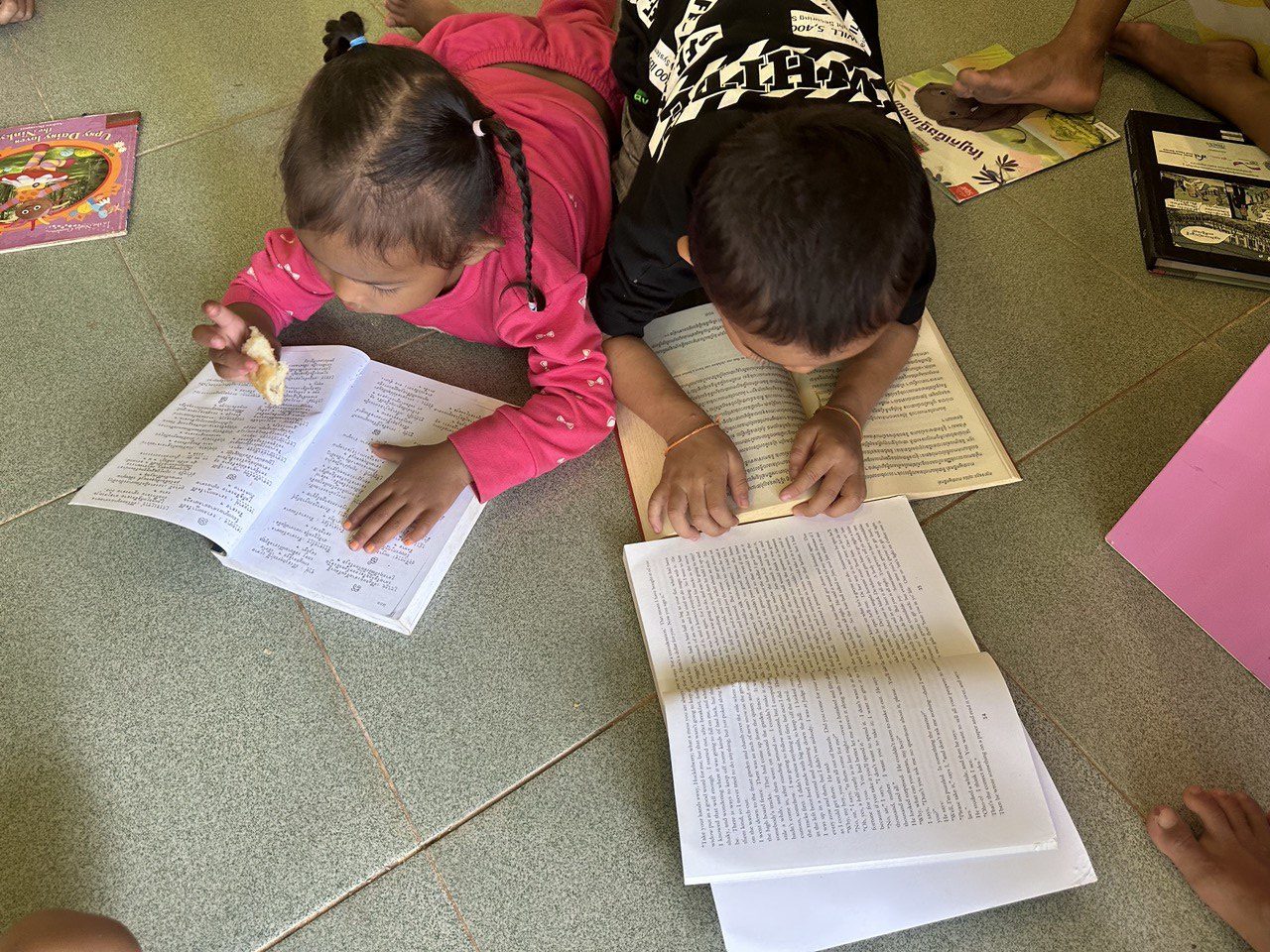 Das Bild zeigt Kinder, die in der Bibliothek des WRC Bücher lesen